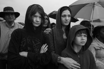 mother and sons standing in the rain